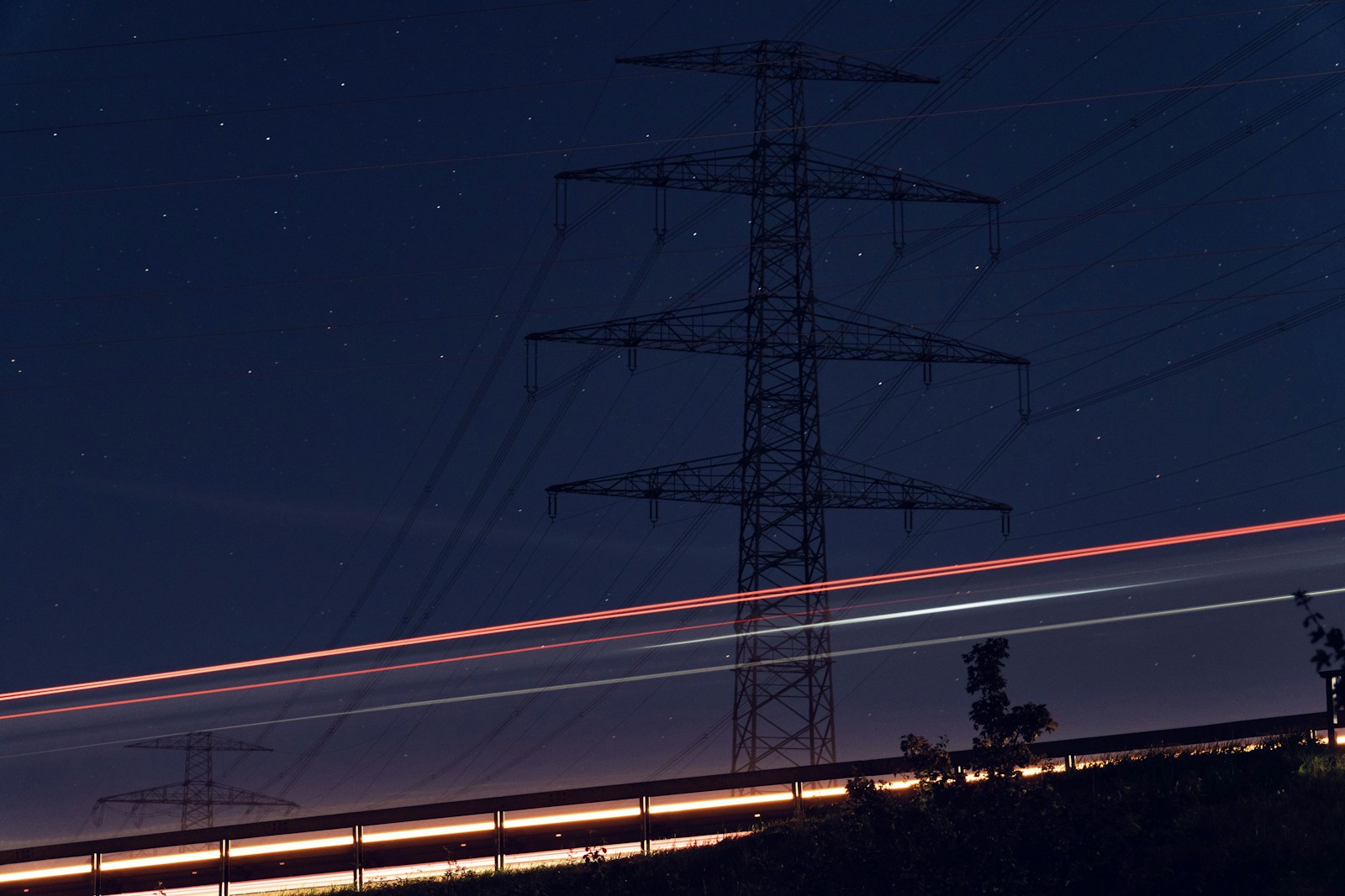 a high voltage power line at night with long exposure